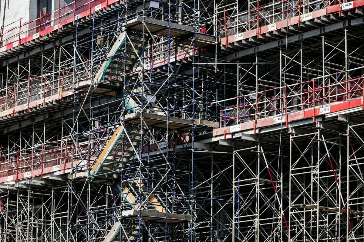 Detailed view of a multi-level scaffolding on a building under construction, shot during daylight.