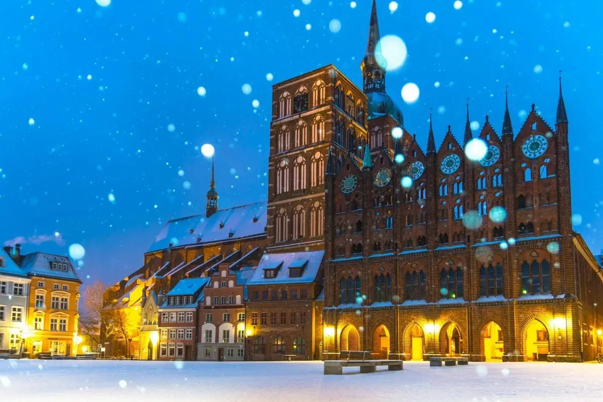 A mesmerizing view of the historic Stralsund Town Hall during a snowy winter night in Germany.