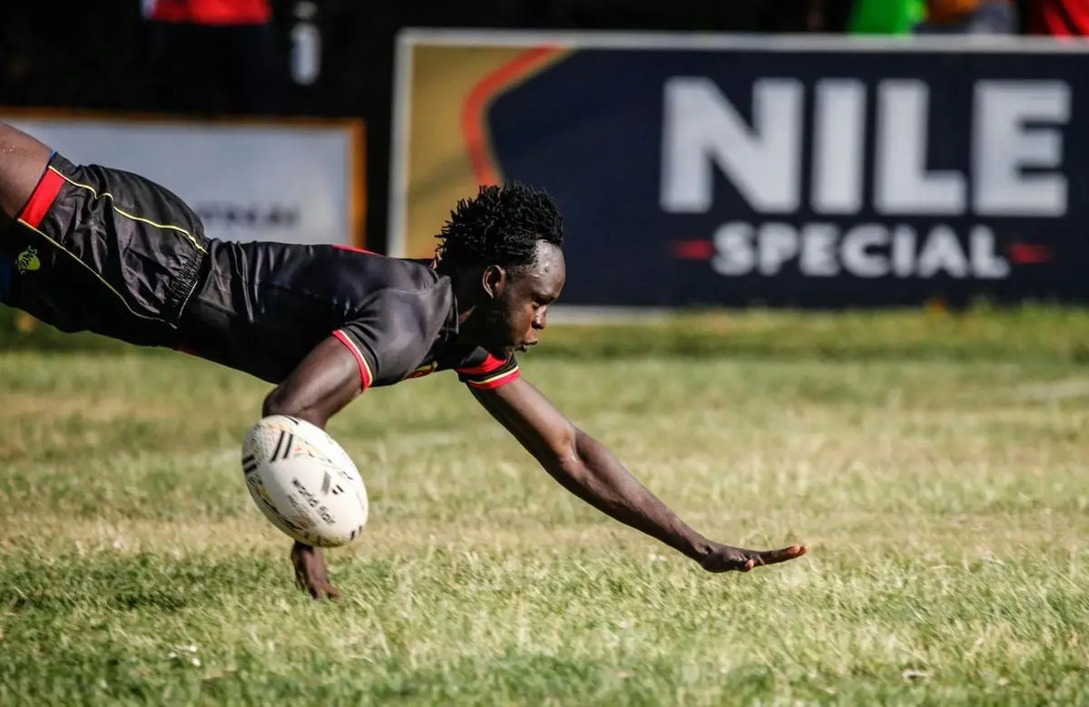 Rugby player in action with ball during outdoor game, showcasing athleticism and speed.