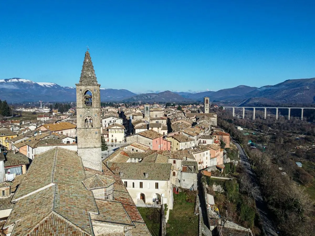 Aerial view of a charming Italian town with historic architecture and distant mountains.