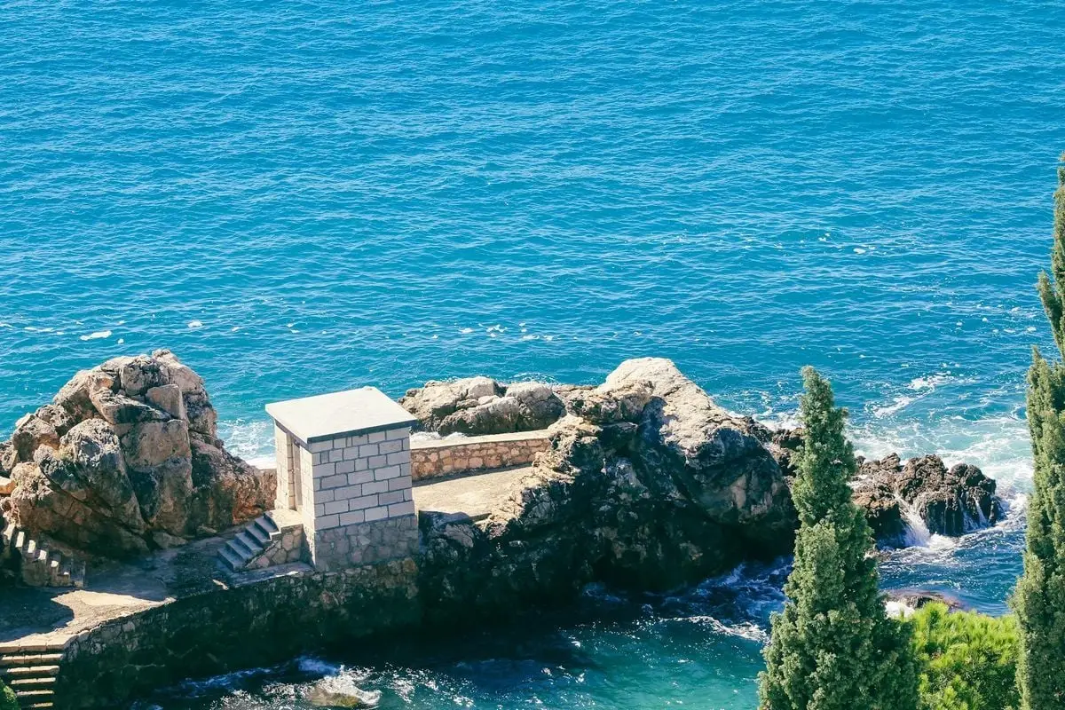 A picturesque view of coastal rock formations by a clear blue sea, capturing nature's beauty.