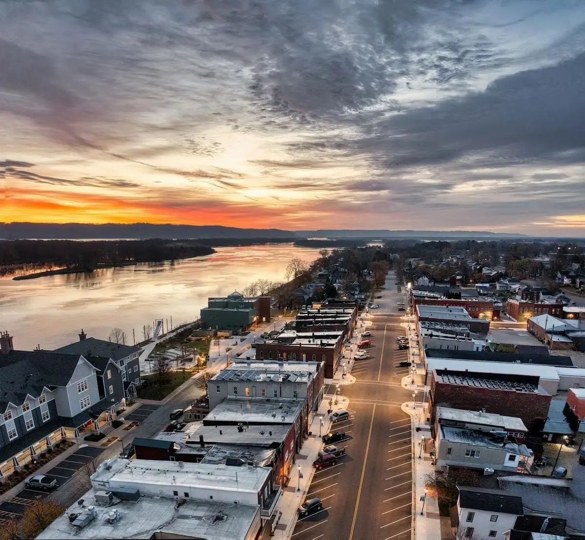 Aerial view of Wabasha, Minnesota at sunset showcasing streets, buildings, and the Mississippi River.