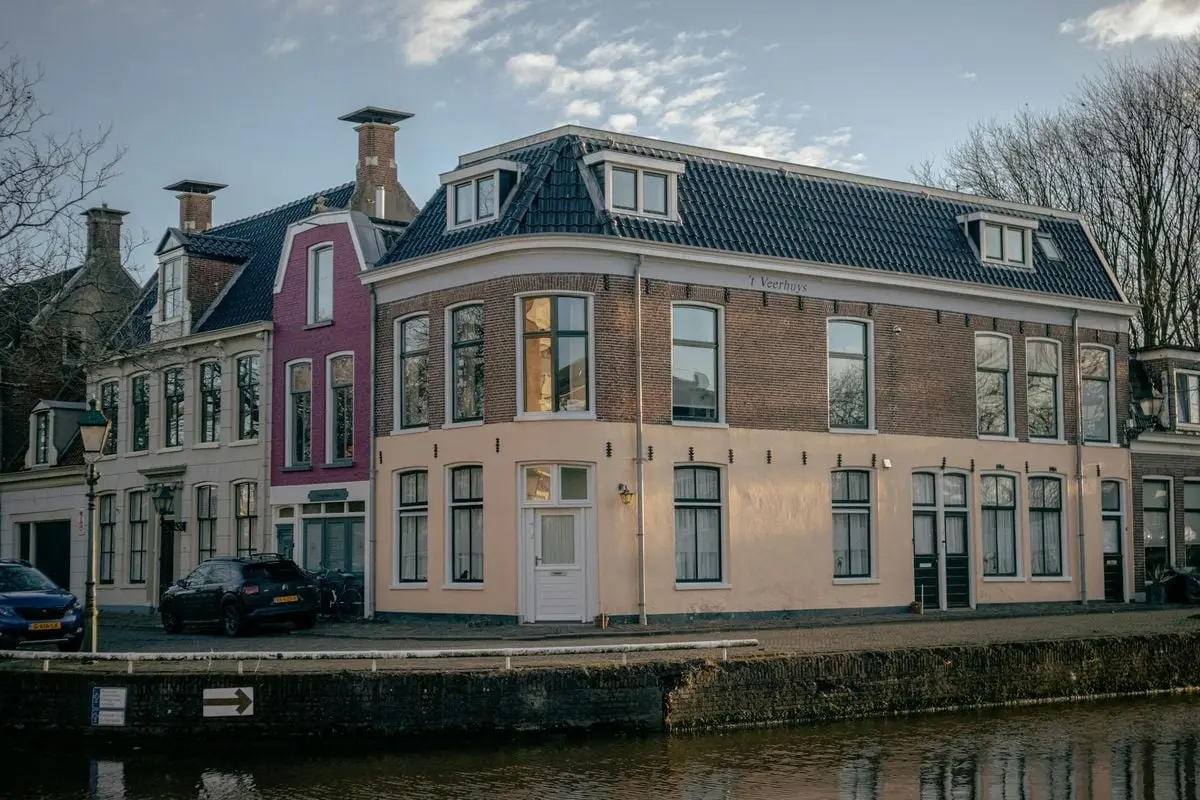 Picturesque view of traditional Dutch houses by a canal in the Netherlands.