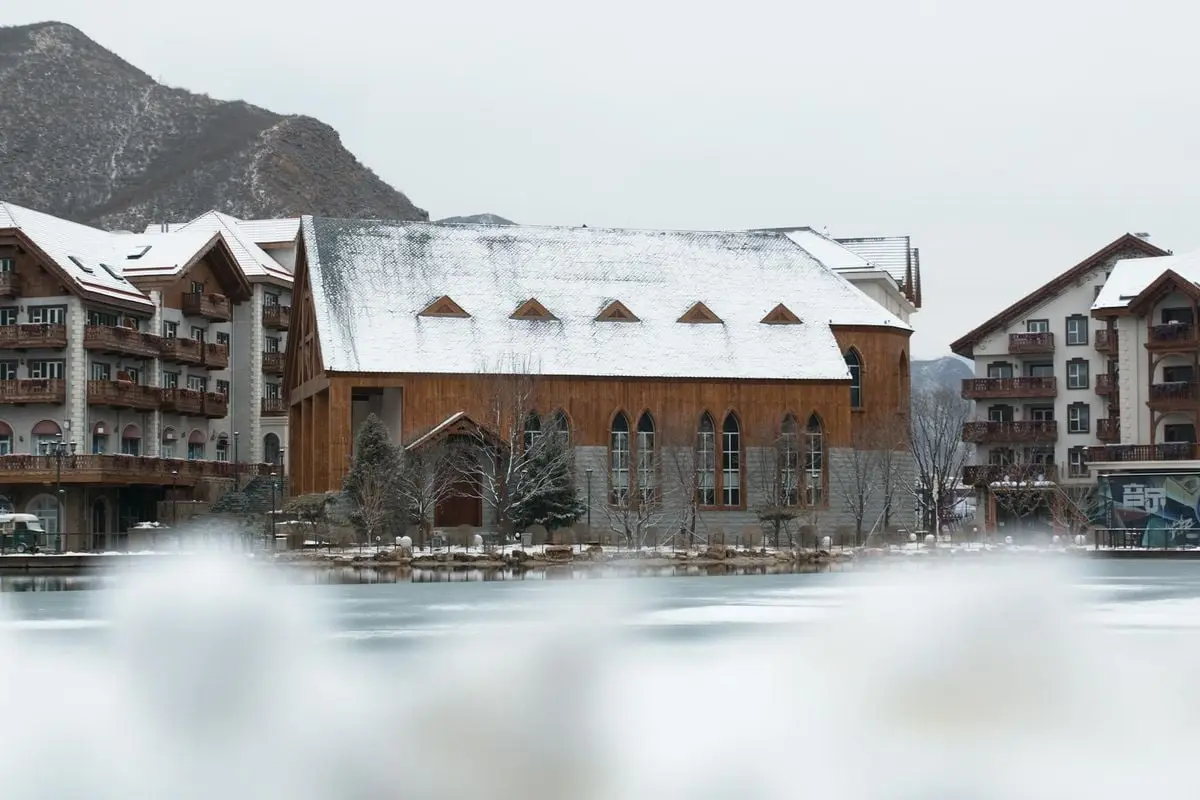 Charming snow-covered buildings in a picturesque winter town with overcast skies.