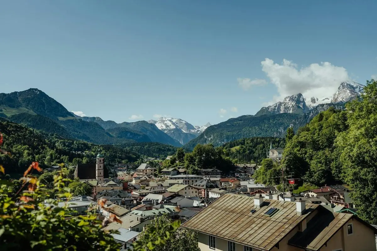 Beautiful view of a Bavarian town nestled in the mountains with clear blue skies.