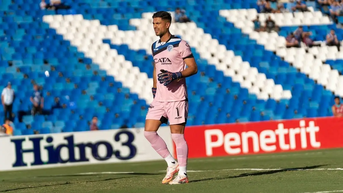 Goalkeeper wearing pink kit on the soccer field during a match.