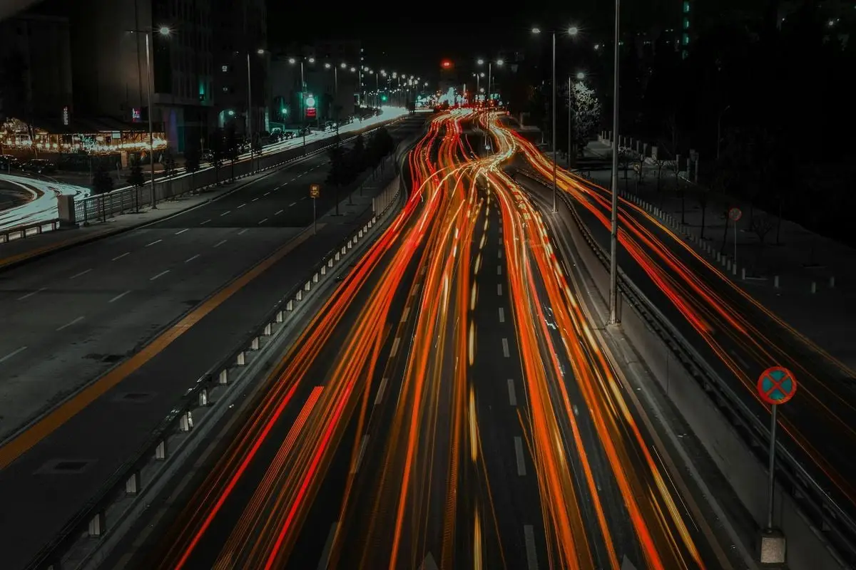 Vibrant city highway at night with dynamic light trails from fast-moving vehicles.