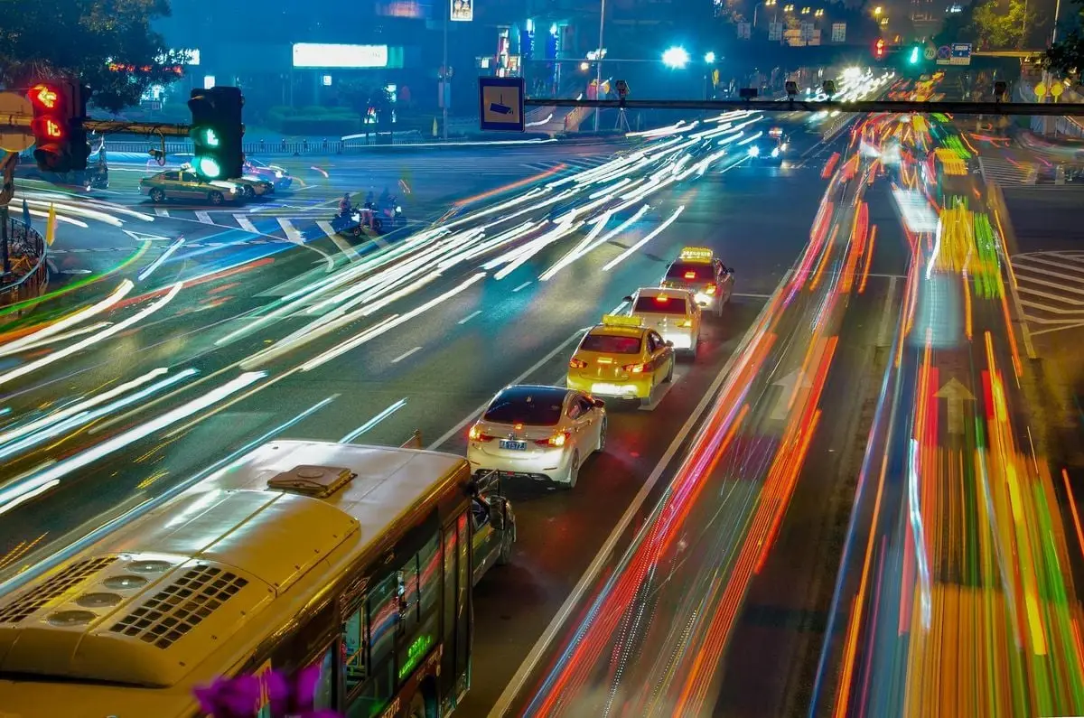 Long exposure of bustling urban traffic in Fuzhou city at night with vibrant light trails.
