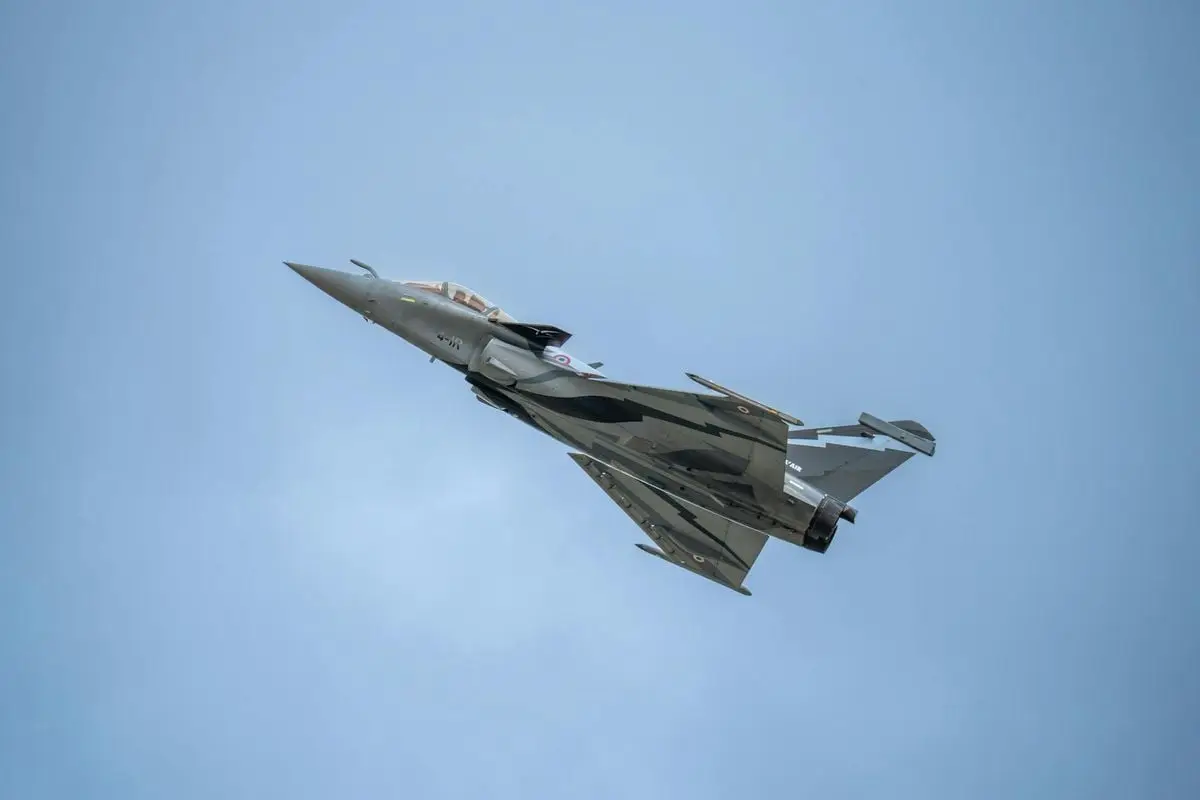 A Dassault Rafale fighter jet soaring in clear blue skies, showcasing aerodynamic design.