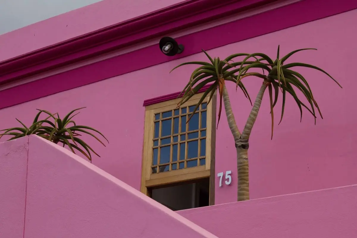 A vibrant pink house in Bo-Kaap, Cape Town, showcasing unique architectural charm.