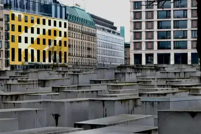 View of modern architecture and Holocaust Memorial in Berlin, showcasing contrast between past and present.