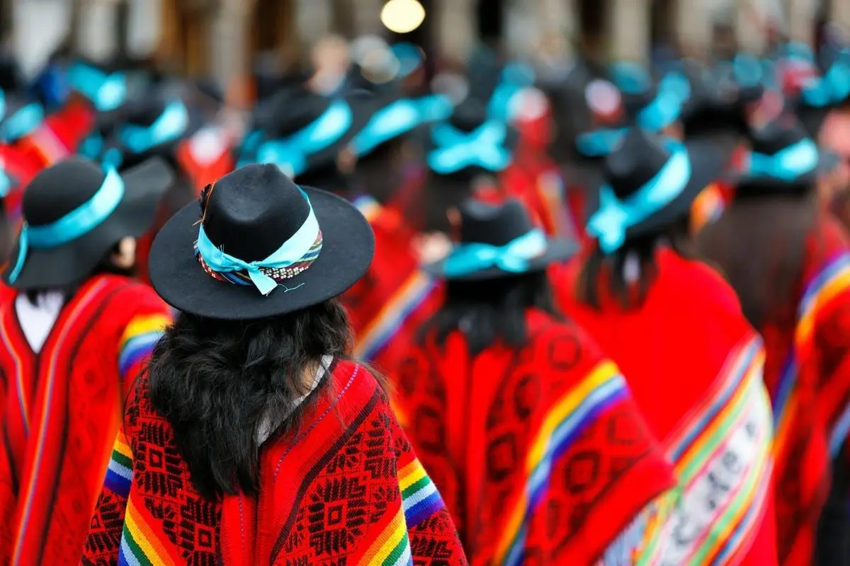 Dynamic street parade in Cusco, Peru showcasing traditional attire and colorful ponchos.