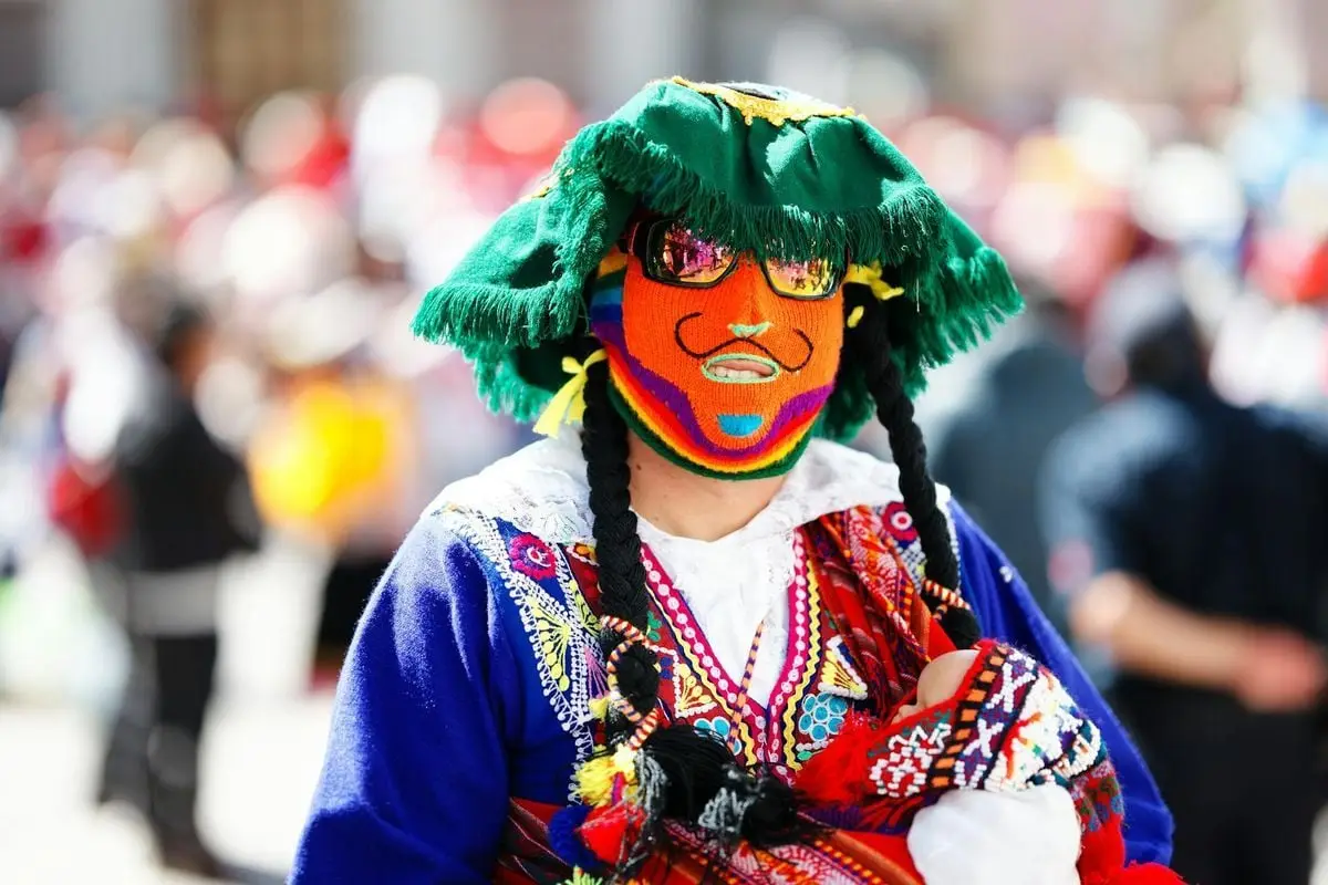 A vibrant dancer with a mask at a traditional festival in Cusco, Peru.