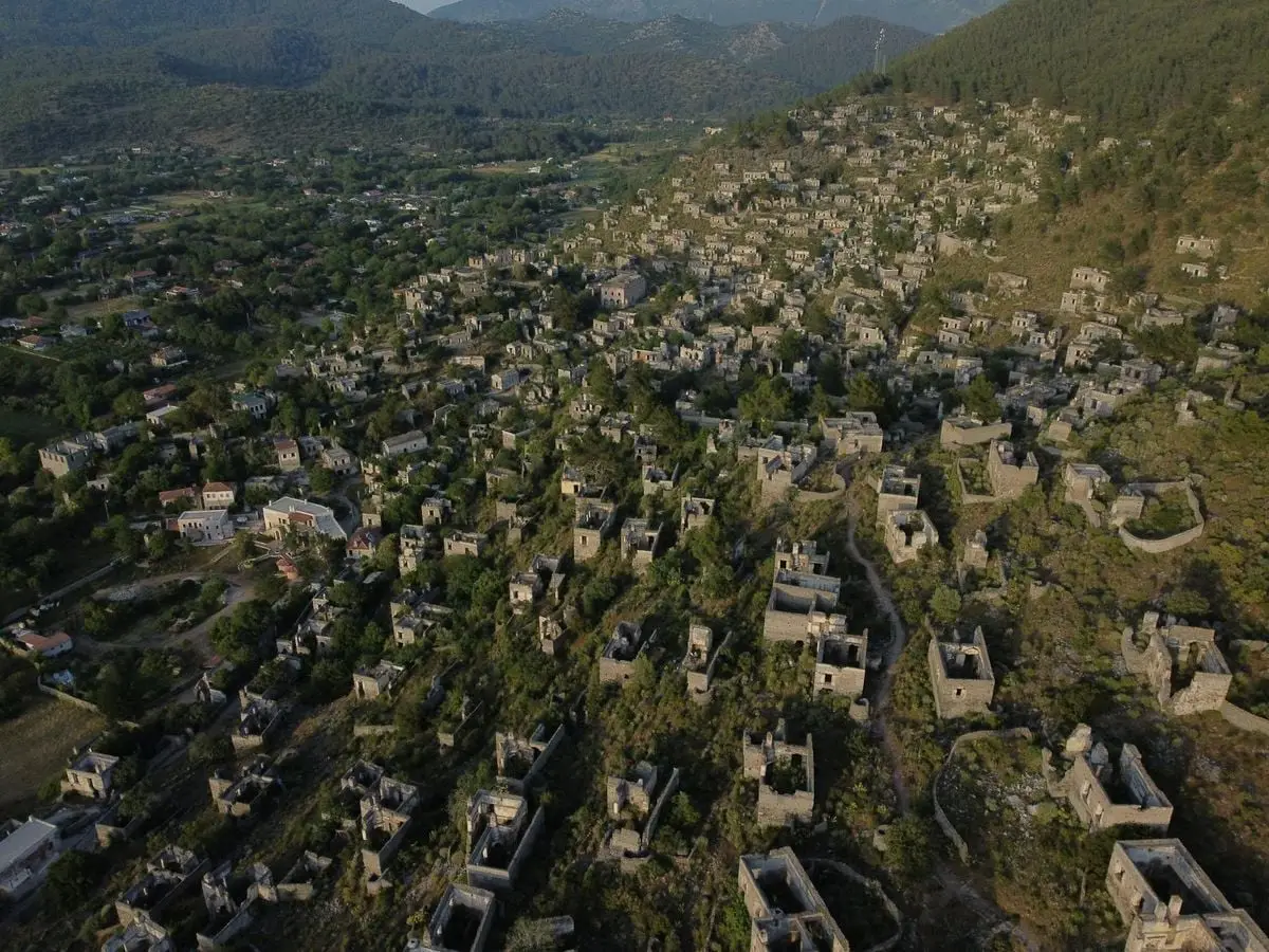 Explore the abandoned stone houses of Kayaköy Ghost Town in Fethiye, Turkey from above.