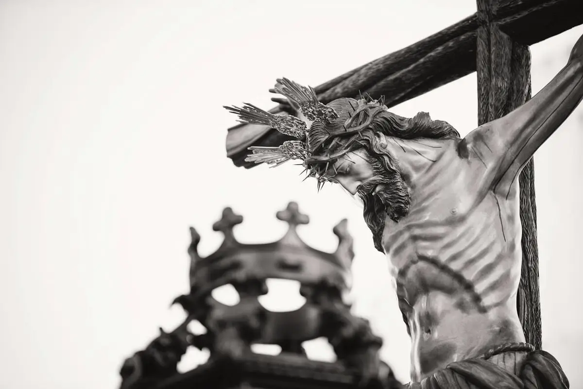 A dramatic close-up of a crucifix statue outdoors in Carmona, Spain, highlighting religious symbolism.