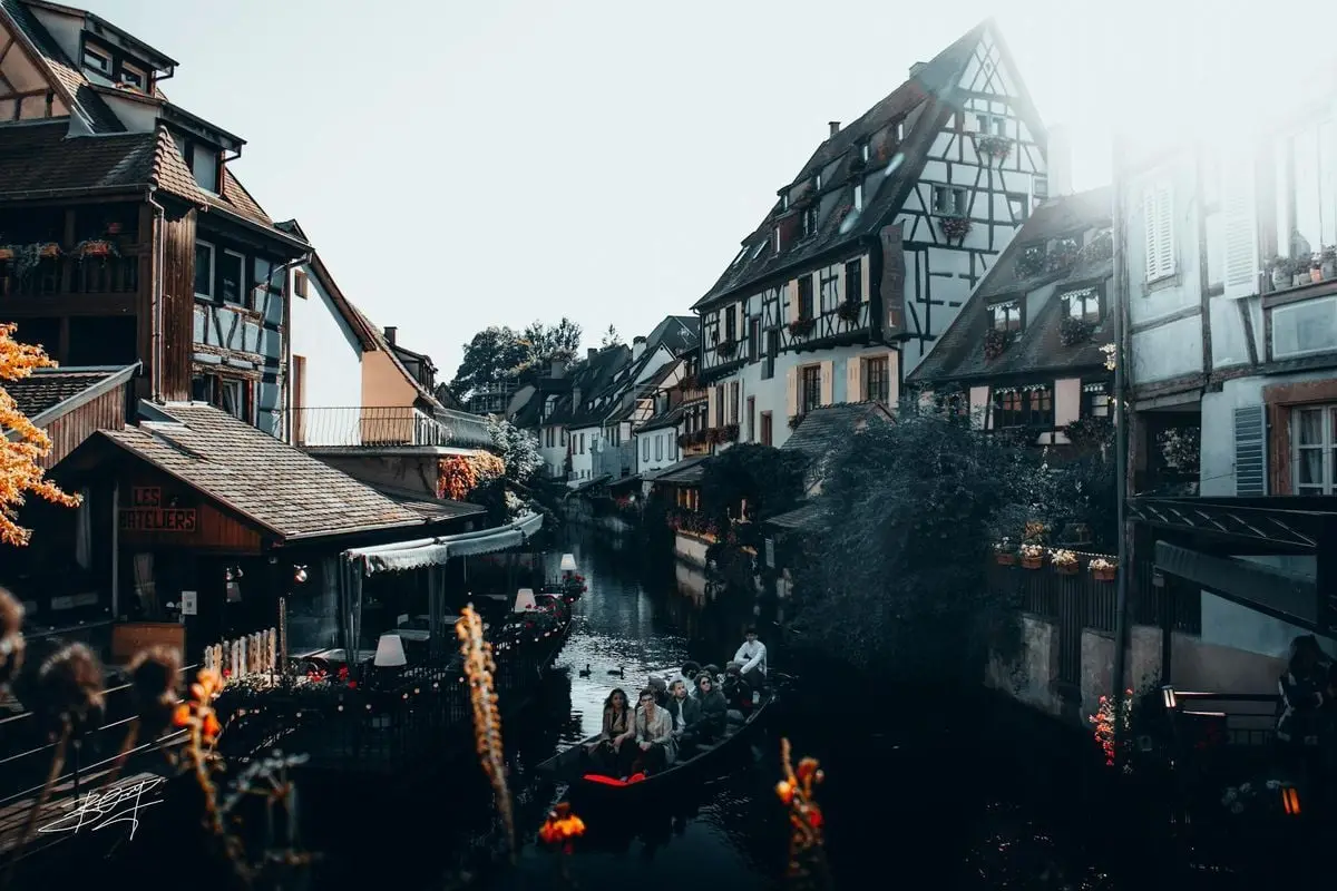Idyllic view of Colmar's canals with half-timbered houses and a boat ride.