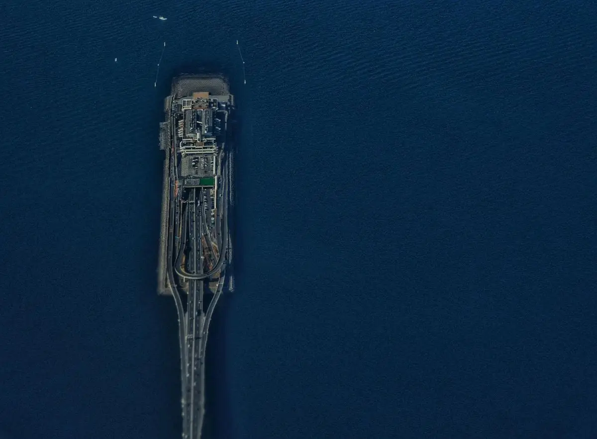Stunning aerial shot of Tokyo Aqua Line bridge extending into the sea, surrounded by blue waters.