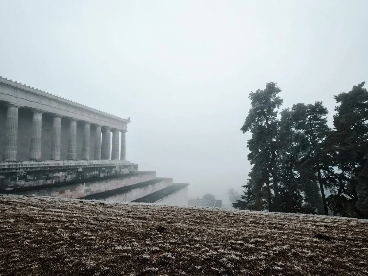 Foggy view of the Walhalla Memorial amidst trees, embodying serene mystery.