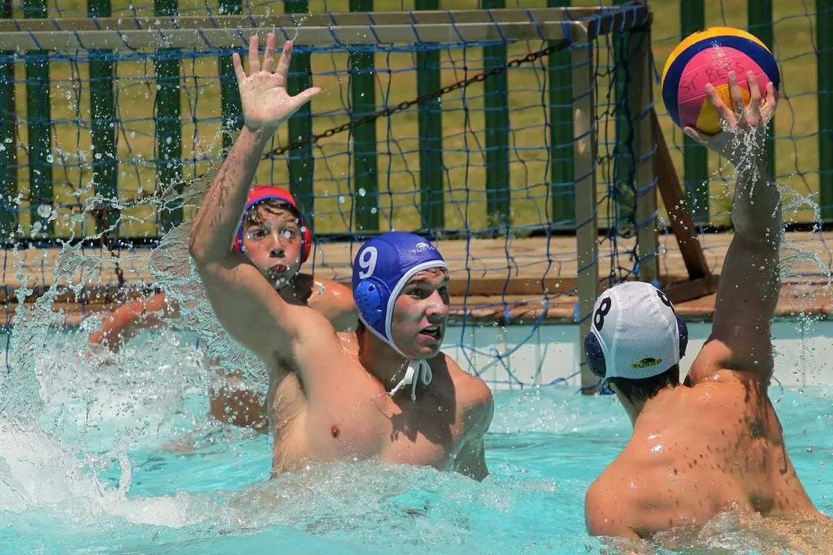 Three male athletes engaging in a dynamic water polo game highlighting sportsmanship and competition.