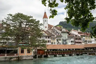 Scenic view of Thun, Switzerland, showcasing historic architecture and vibrant river setting.