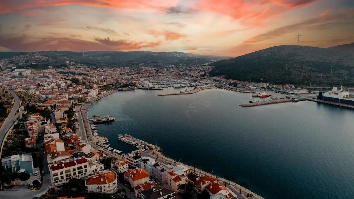 A breathtaking aerial view of Çeşme Harbor in İzmir, Türkiye with a vibrant sunset sky.