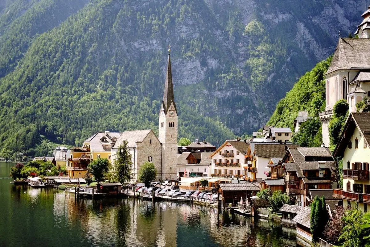 Discover the picturesque town of Hallstatt by the lake, surrounded by lush alpine landscapes.