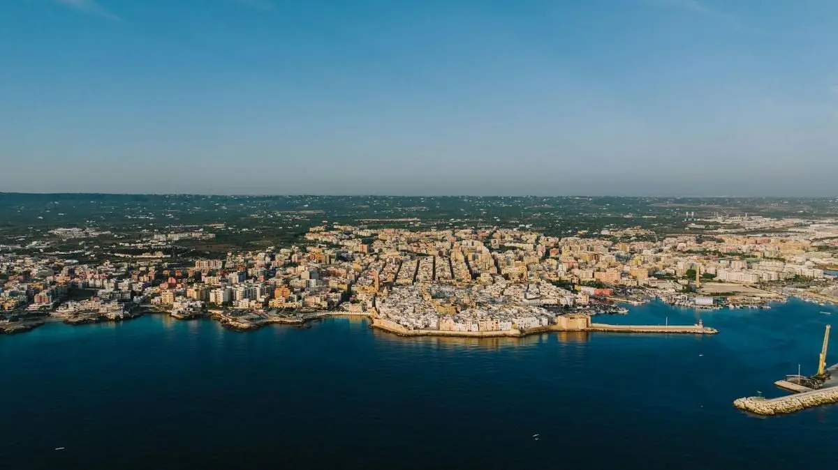 Aerial shot of Monopoli, Apulia, Italy, showcasing the seaside town's architecture and harbor.