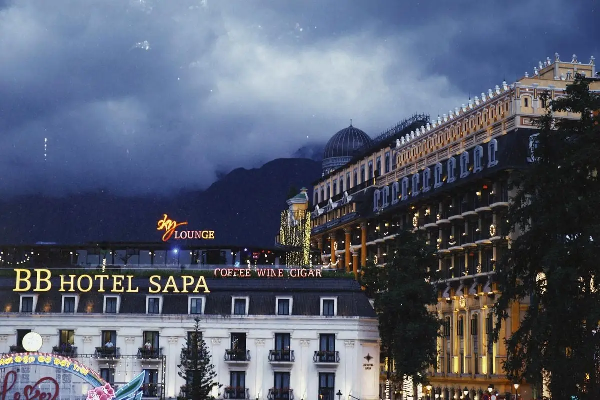 Scenic nighttime view of BB Hotel Sapa with atmospheric lighting and urban architecture.