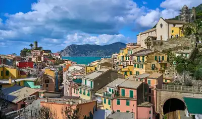Panoramic view of Vernazza's colorful buildings against a coastal backdrop in Cinque Terre.