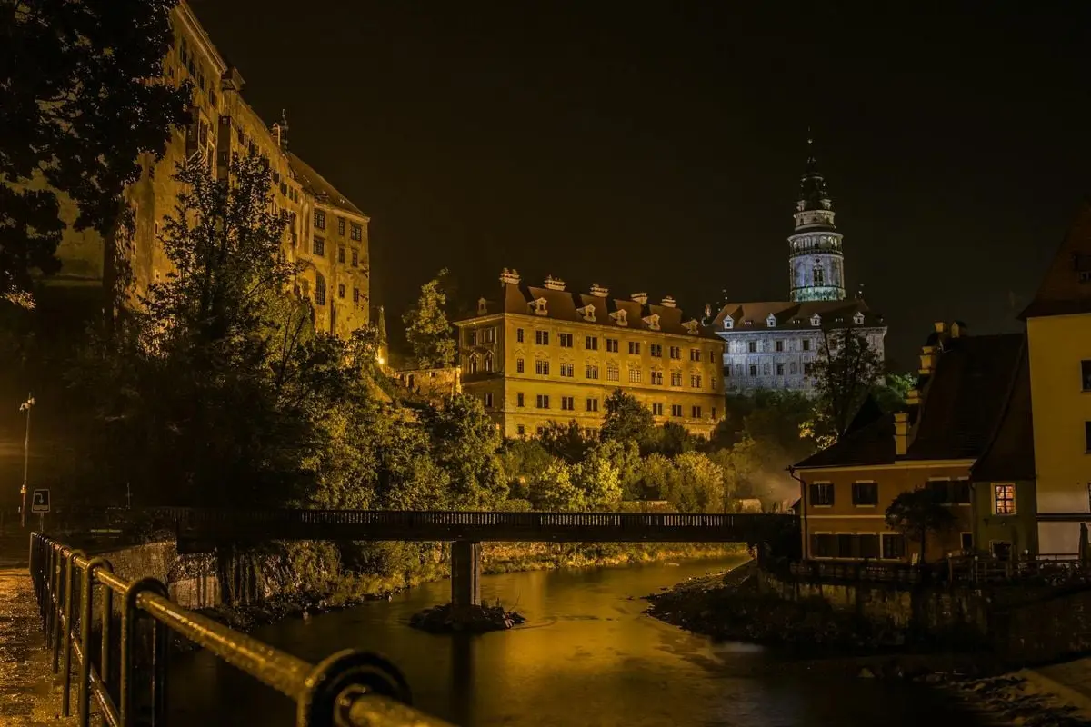 Enchanting night view of Český Krumlov with the illuminated castle and serene river backdrop.