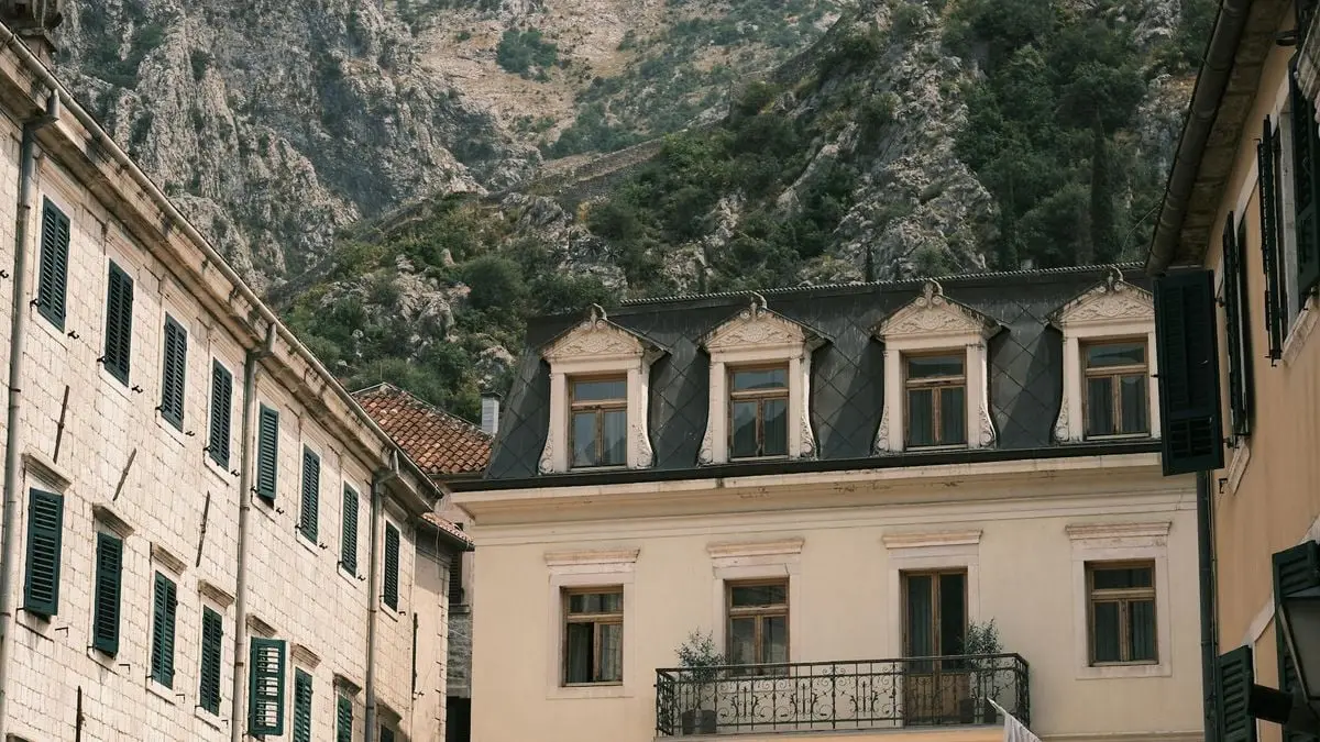 Elegant building exterior in an old town with a rugged mountain backdrop, offering a sense of historical charm.