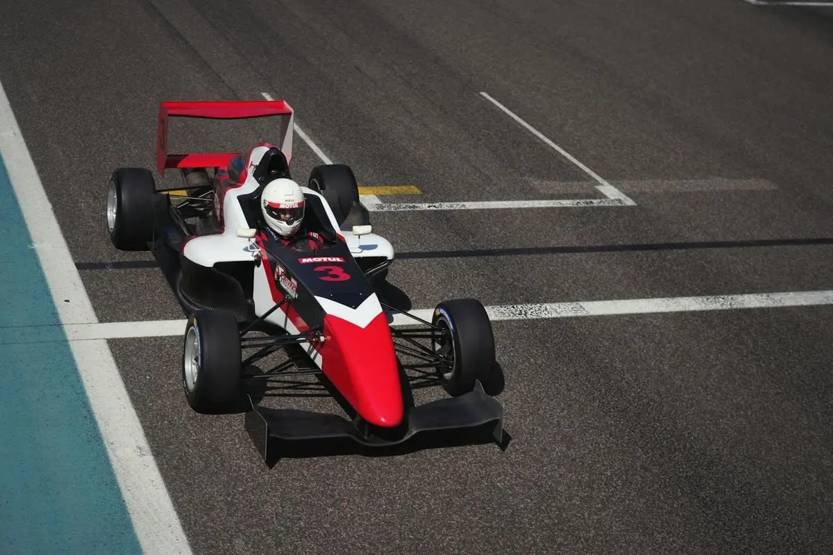 Dynamic image of a race car on a track in Abu Dhabi, showcasing speed and precision.
