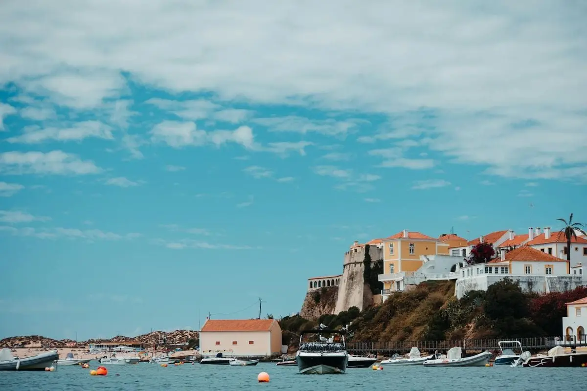 Charming coastal town with vibrant buildings and boats under a clear blue sky.