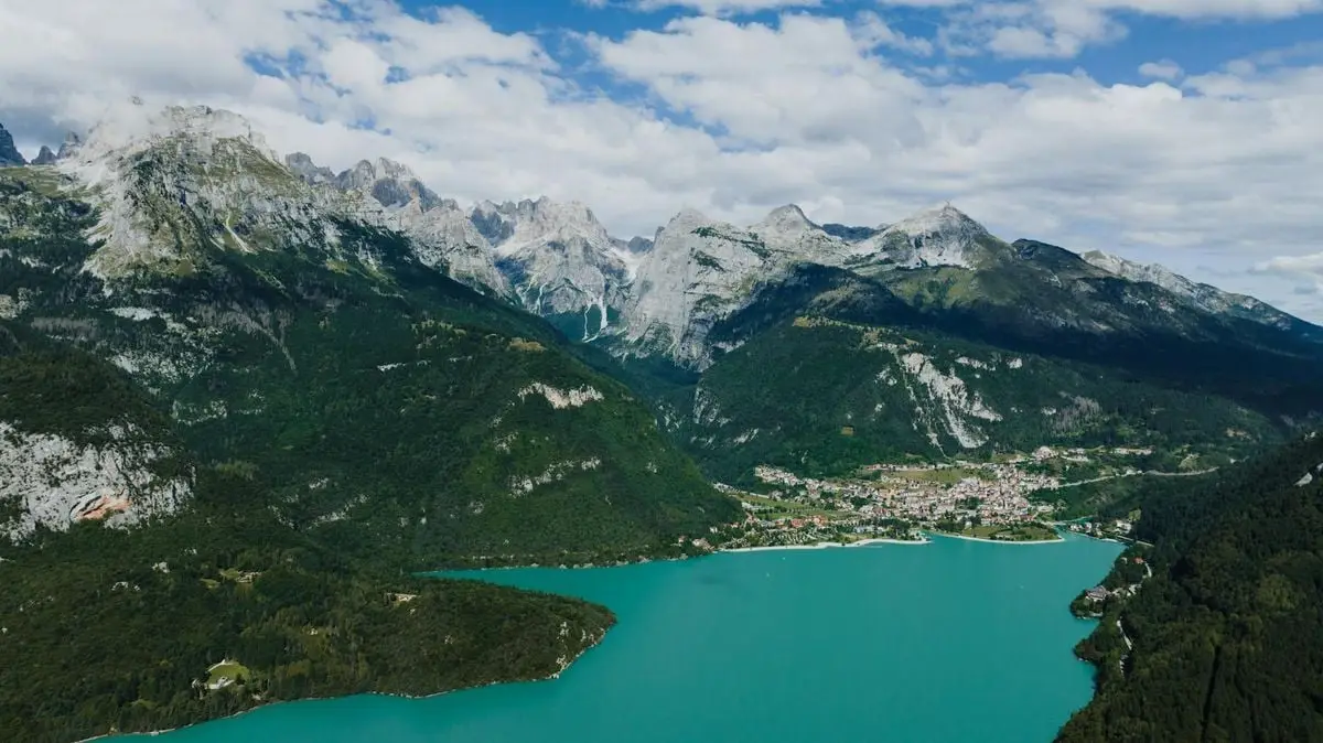 Stunning aerial view of Molveno Lake nestled among picturesque mountains in Trentino, Italy.