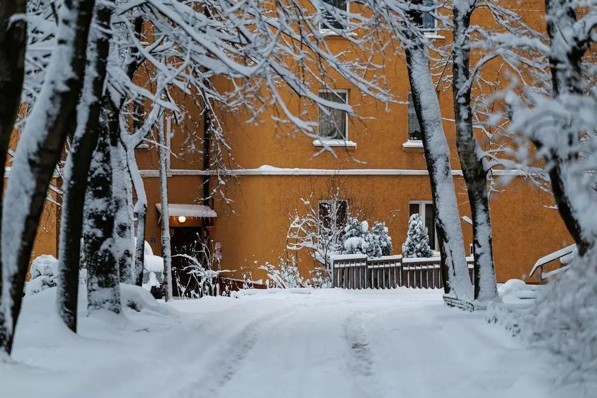 Quiet snowy courtyard with orange building in Kaliningrad, winter scene.
