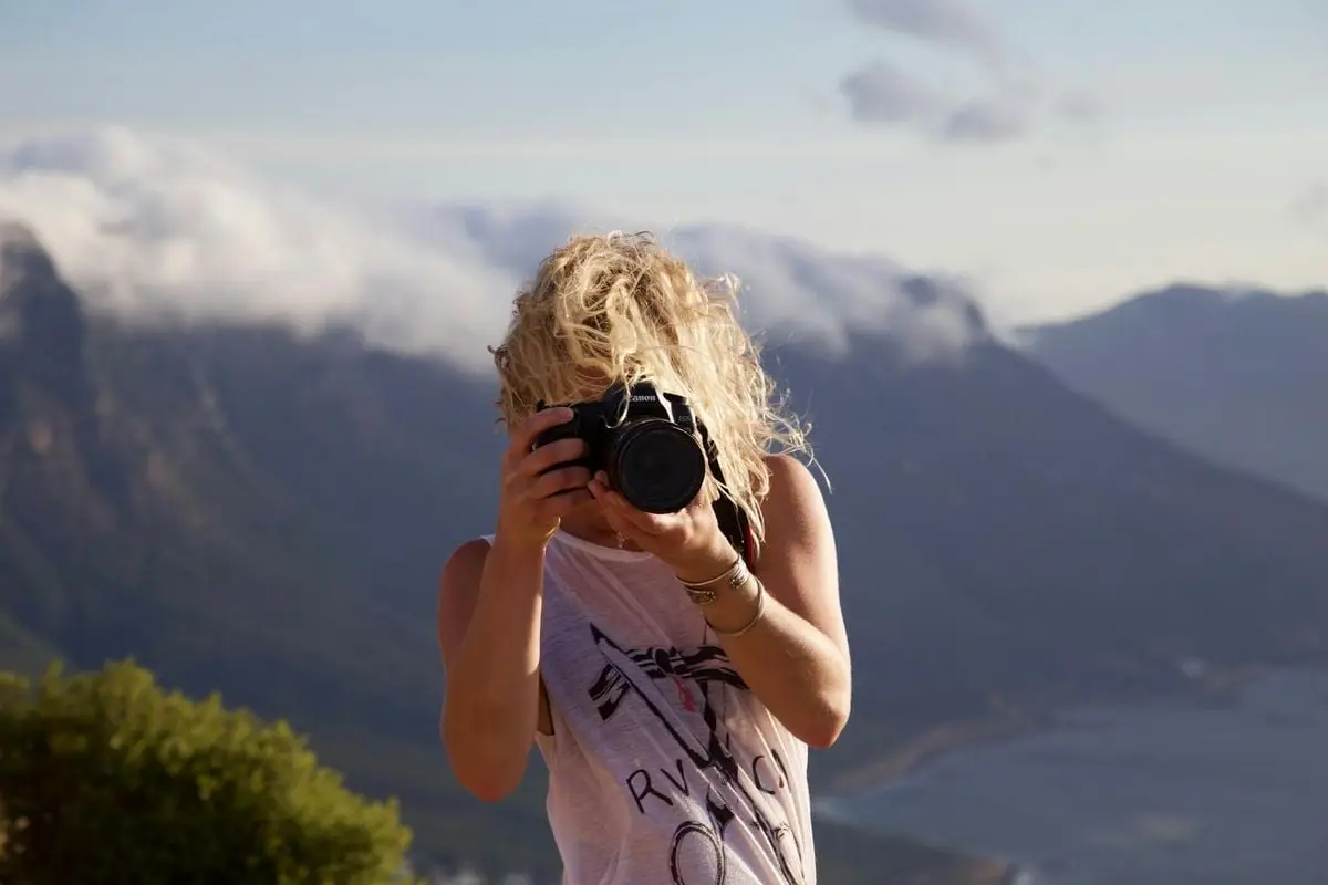 A woman enjoys photographing the scenic mountain landscape in Cape Town, South Africa.