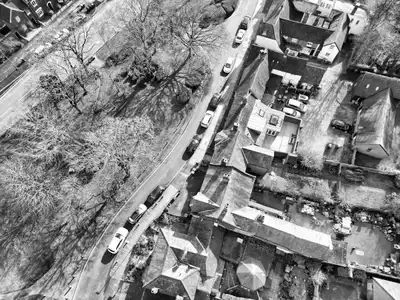 Aerial black and white photo of a charming town in Hertfordshire, showcasing houses and streets.