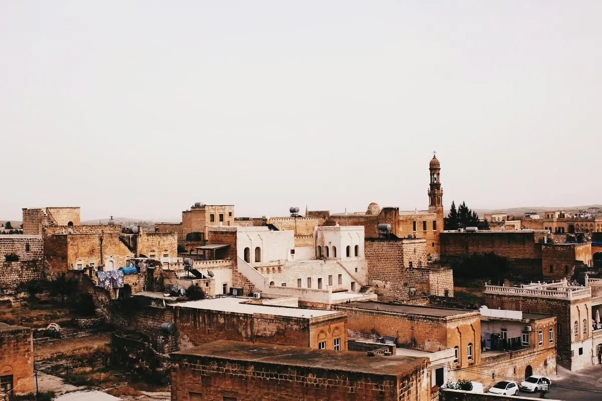 A picturesque view of a Middle Eastern city with rustic architecture during sunset.