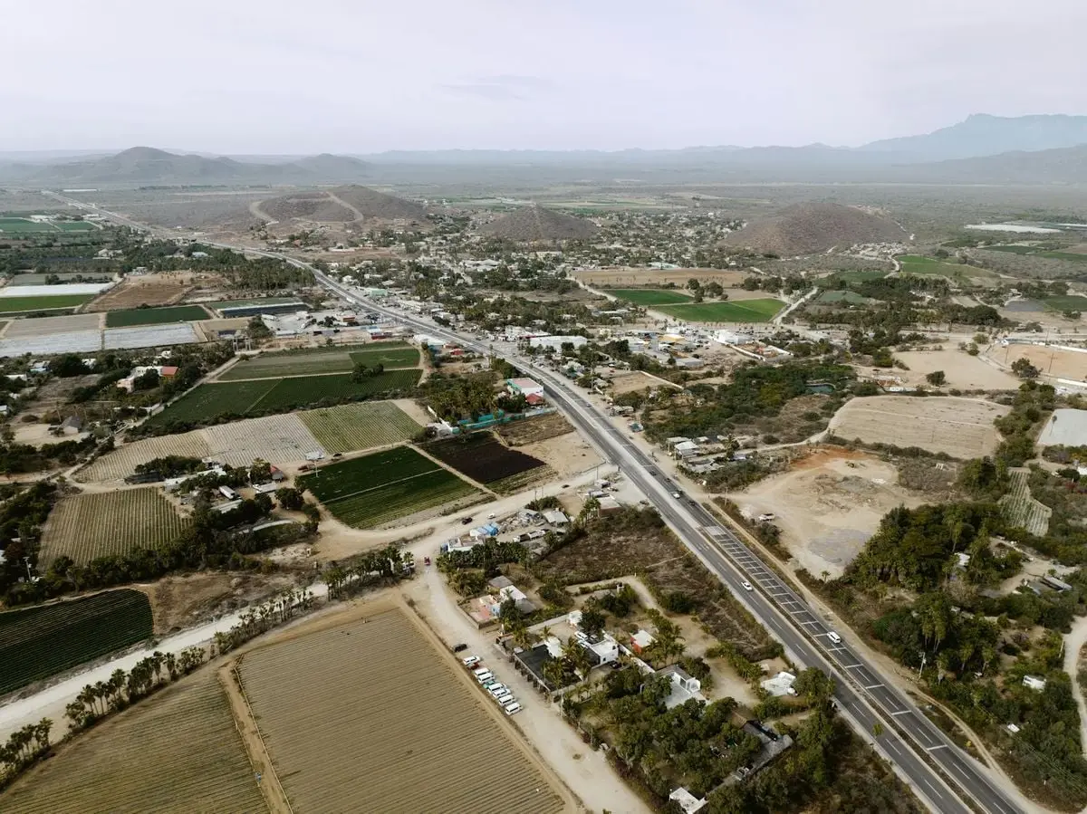 Scenic aerial view of El Pescadero, BCS, Mexico showcasing farmland, roads, and mountains.