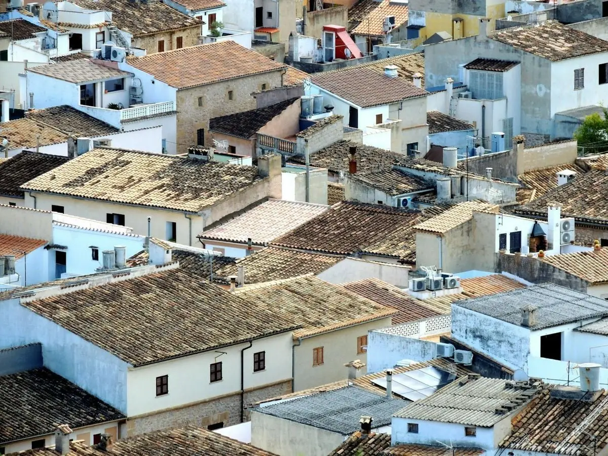 Charming aerial view of traditional tiled rooftops in Pollença, Spain.