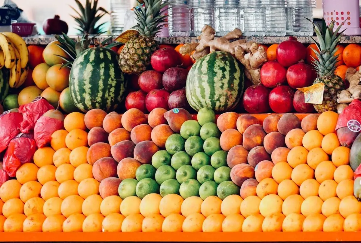Colorful display of fresh fruits at a market stall, showcasing a variety of tropical produce.